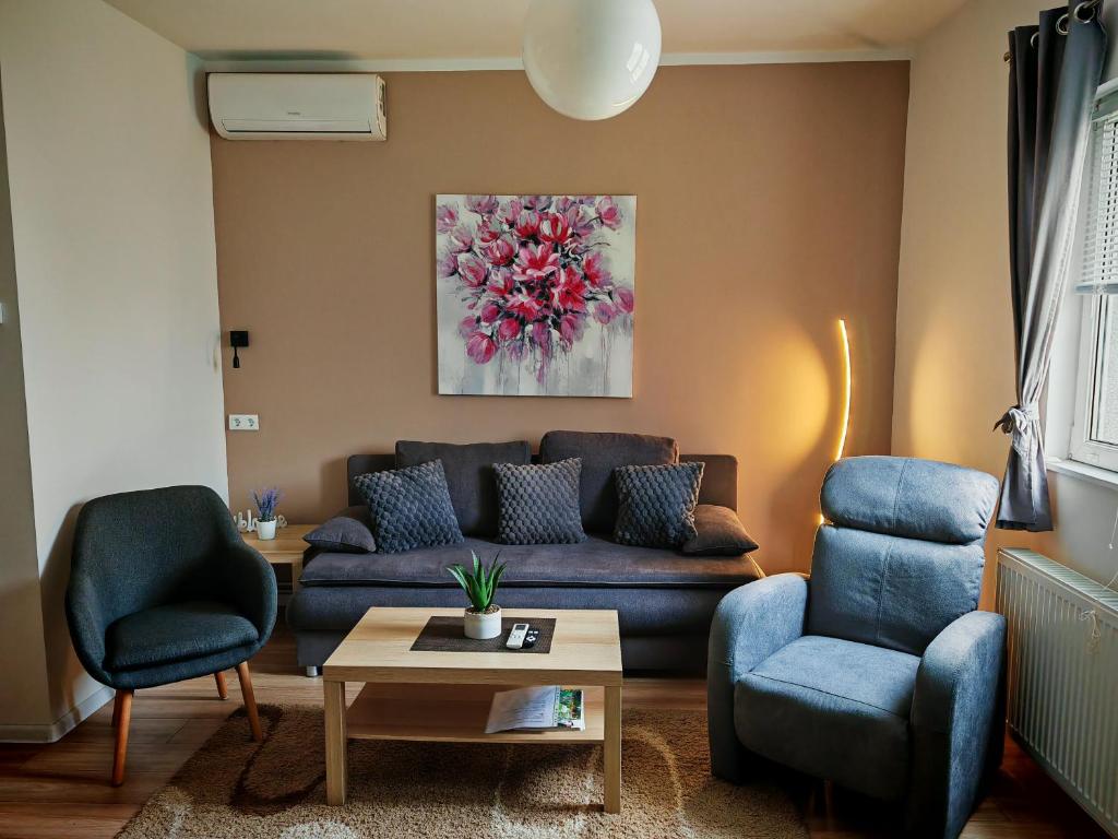 un soggiorno con divano blu e 2 sedie di Apartman - sobe Corina-blizu Osijeka a Bilje