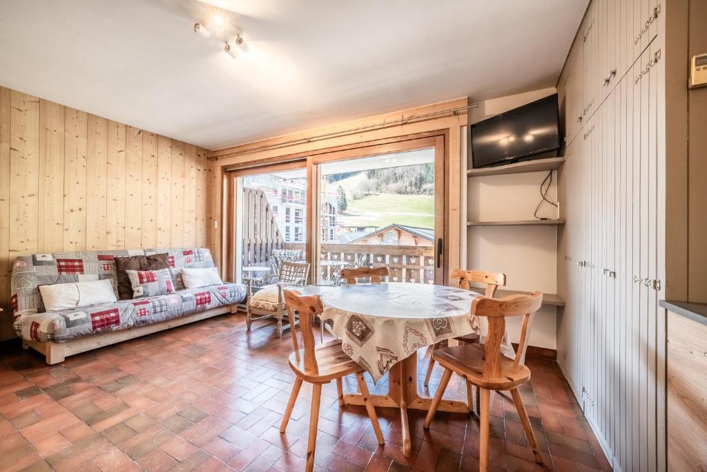 une salle à manger avec une table, des chaises et un canapé dans l'établissement OLYMPIQUE S4 Studio au pied des pistes et de l'ESF, à Morzine