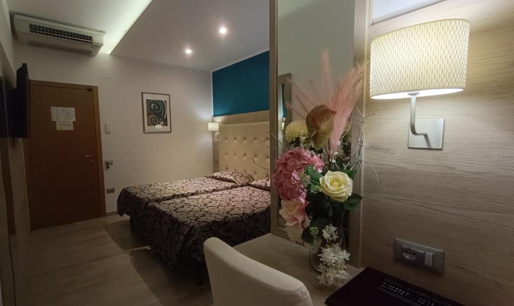 a hotel room with a bed and a mirror at Hotel Baffo Rosso in Alba Adriatica