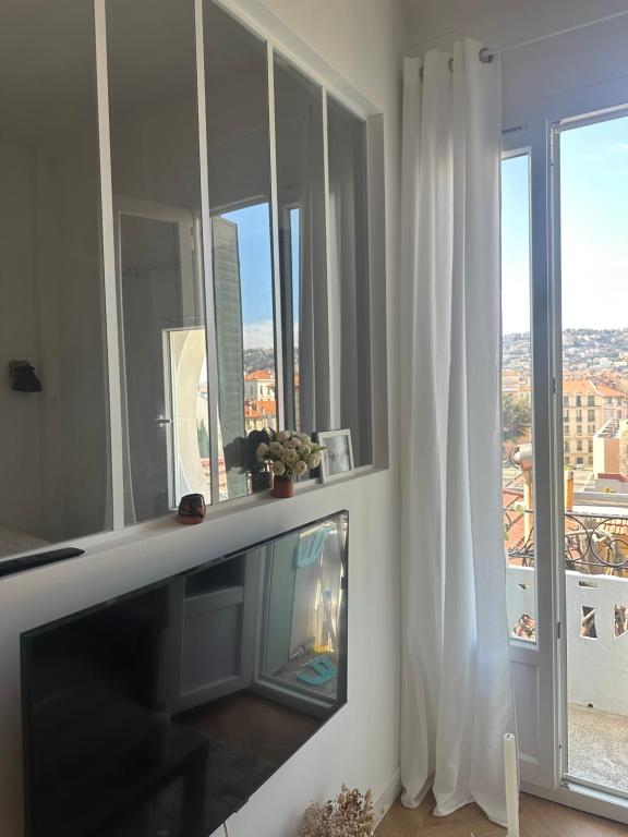 un salon avec une télévision et une cheminée dans l'établissement Studio libération, à Nice