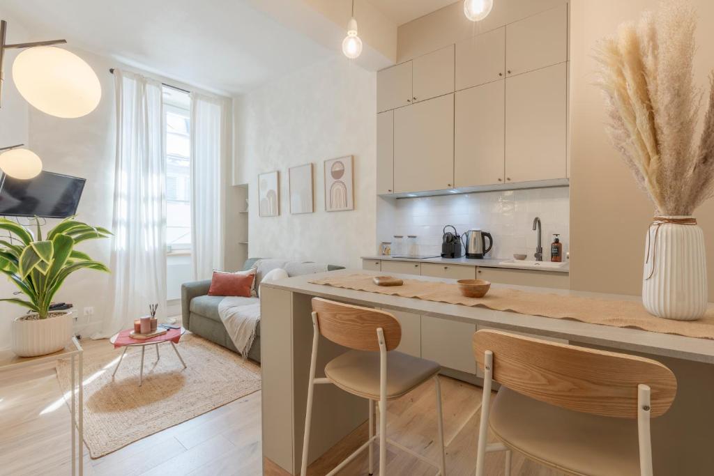 une cuisine et un salon avec un comptoir et des chaises dans l'établissement Hypercentre - Le Balcon des Pyrénées, à Pau