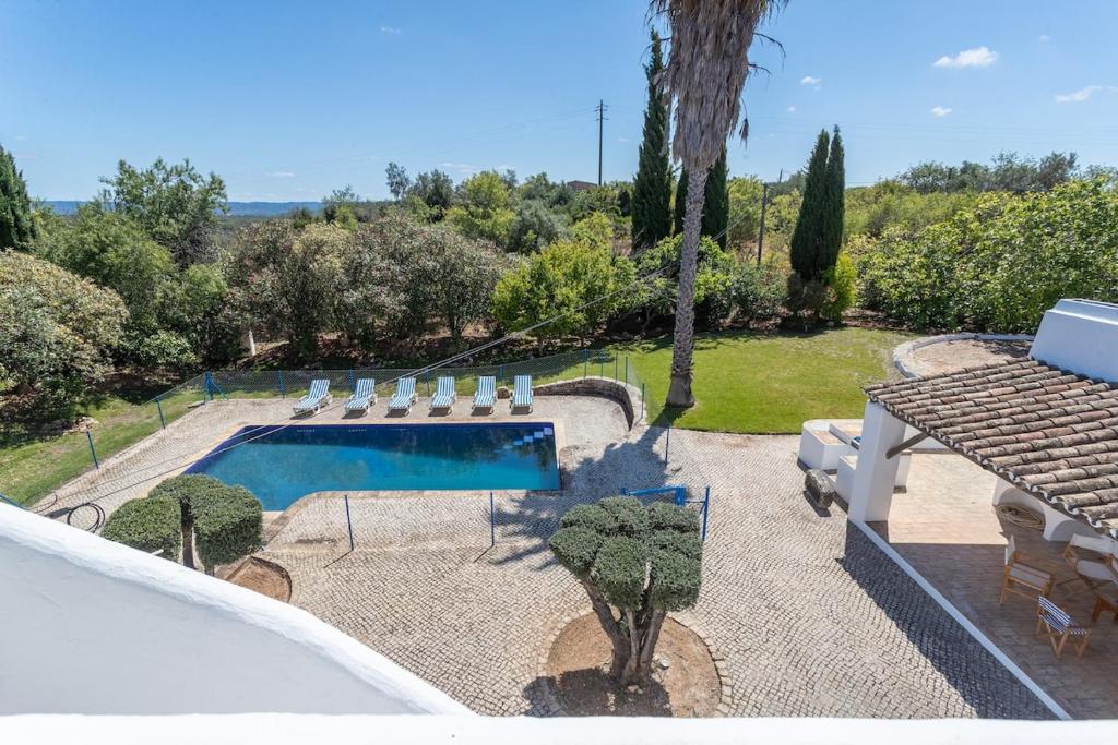 une piscine dans une cour avec une table et des chaises dans l'établissement True Local Village, à Loulé