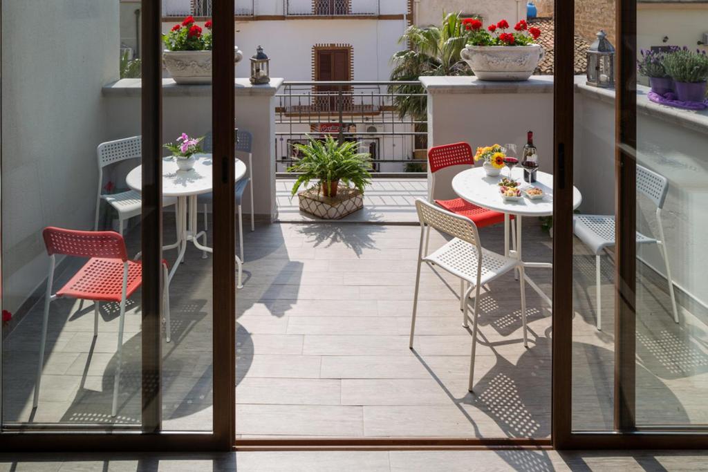 a patio with tables and chairs on a balcony at Arricàmpati Airport Home & Bringo Car Rental in Carini