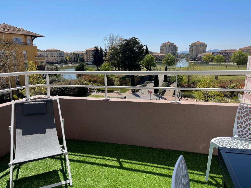 un balcon avec des chaises et une vue sur la ville dans l'établissement Bel appartement,2 chambres, clim, vue, parking, à Lattes