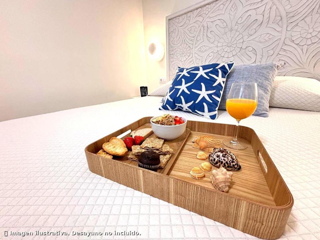 a tray of food and a glass of wine on a bed at Brisa Marina Stay a unos pasos del mar in Valencia