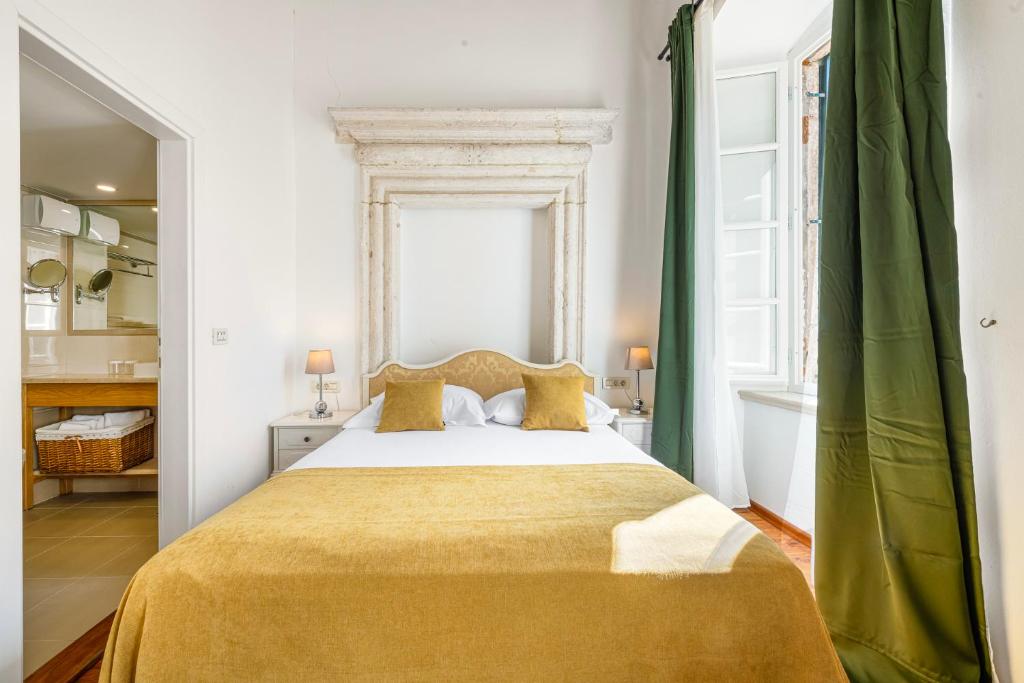a bedroom with a large bed and a tub at Palmotta Palace in Dubrovnik
