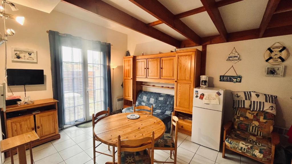 une cuisine avec une table en bois et un réfrigérateur dans l'établissement Le Marin des Vertmarines, à Saint-Jean-de-Monts