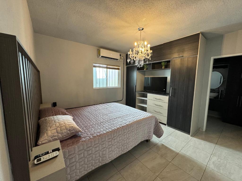 a bedroom with a bed and a chandelier at Estancias Nava #2 in San Antonio