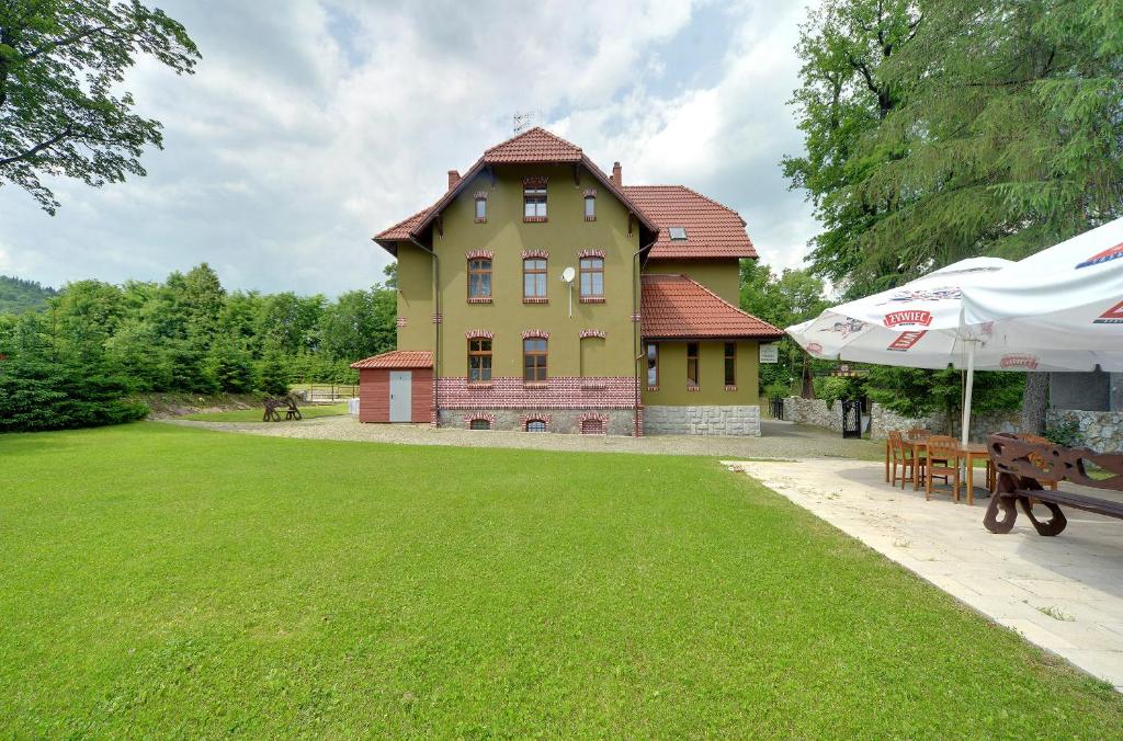 una grande casa con un prato verde davanti di Gościniec Rudawski a Kamienna Góra