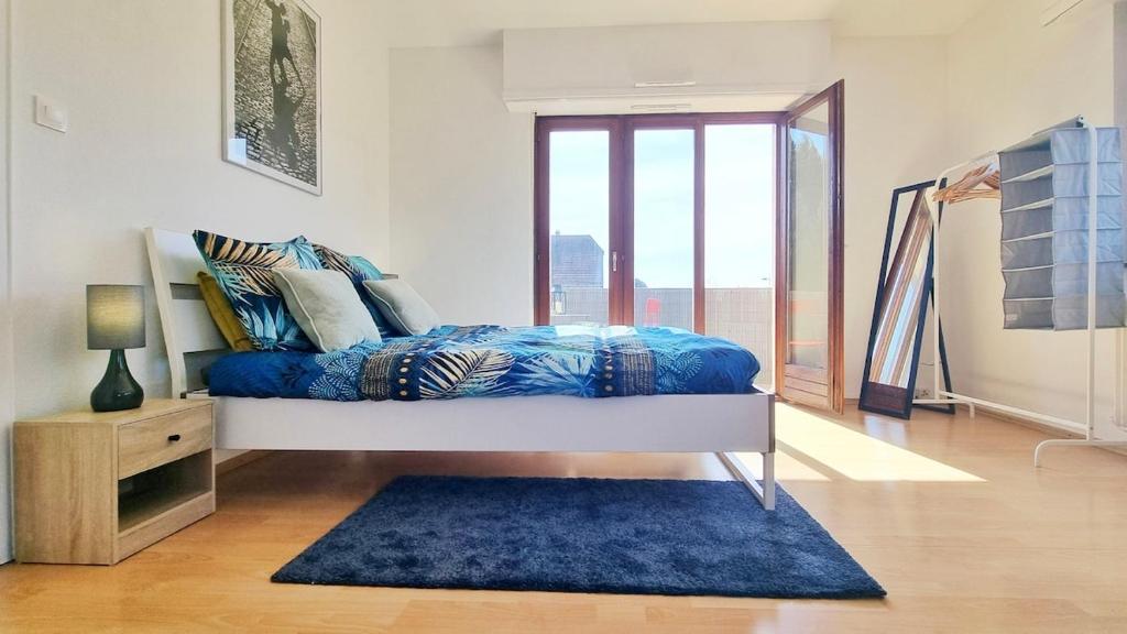 - une chambre avec un lit et un tapis bleu dans l'établissement Les Aubépines - Calme - Parking, à Colmar