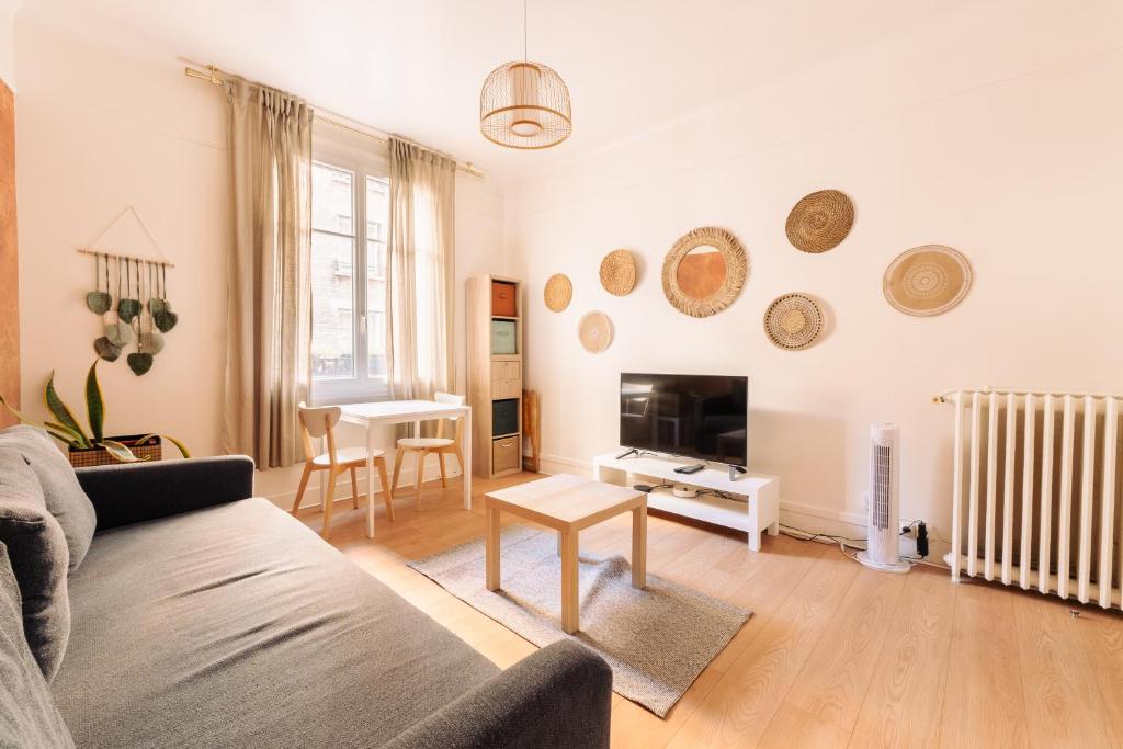 un salon avec un canapé et une table dans l'établissement Le Pinky Bird - Lafayette Paris, à Paris