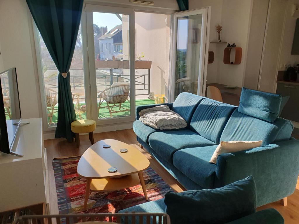un salon avec un canapé bleu et une table dans l'établissement Superbe appartement 4 personnes, à Pornichet