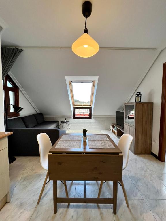 a living room with a table and a couch at Atico en Tina Mayor in Unquera