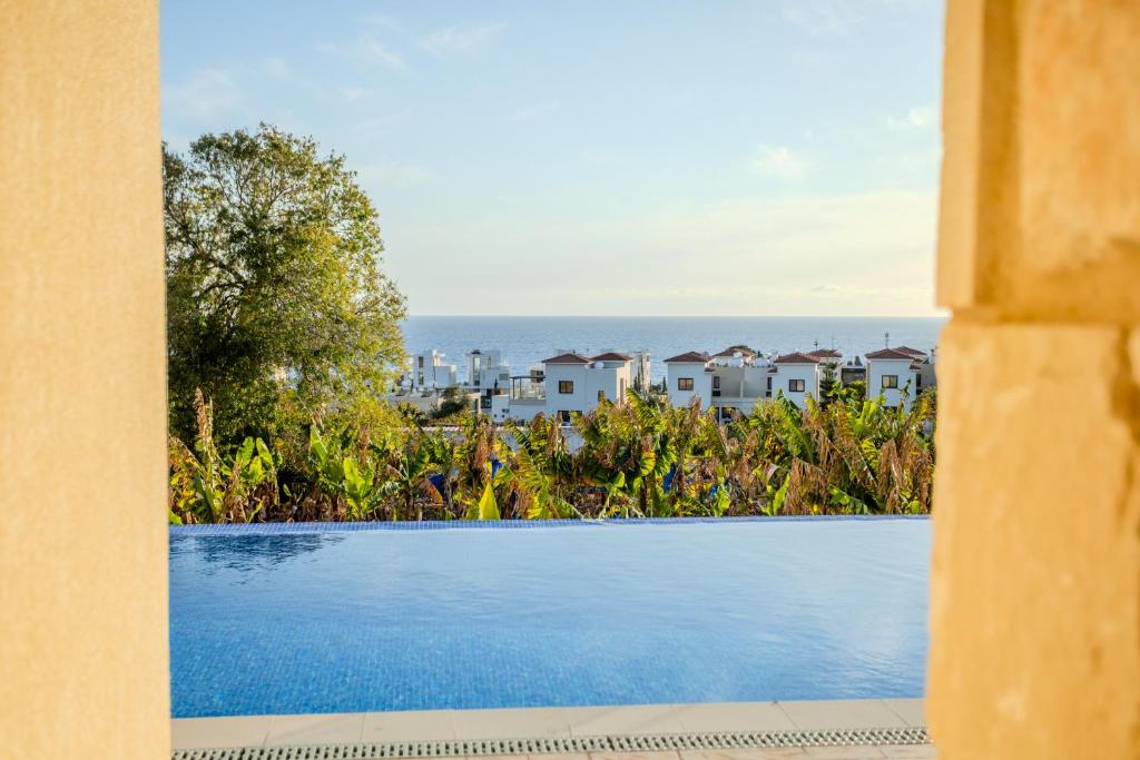 a view of the ocean from a resort swimming pool at H&O Miki's Seaview House in Kissonerga