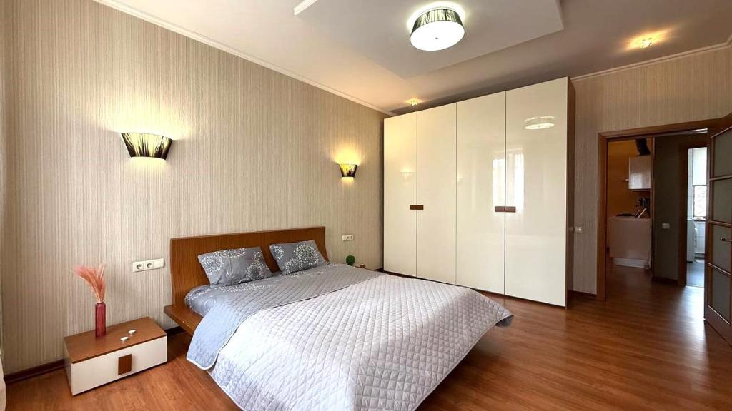 a bedroom with a large bed and a wooden floor at Calm Central Apartment in Kharkiv
