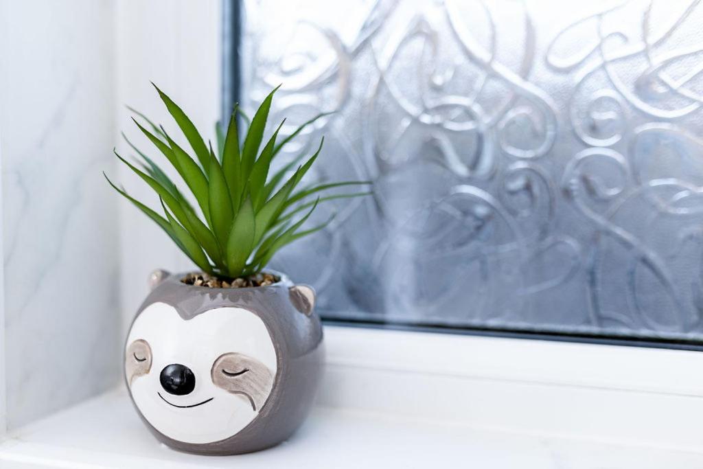a vase with a potted plant sitting on a window sill at Prestige Homes, Harwich in Parkeston