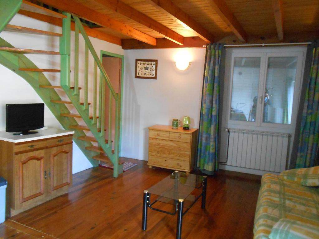 a living room with stairs and a tv and a couch at Gite du plô in La Cresse