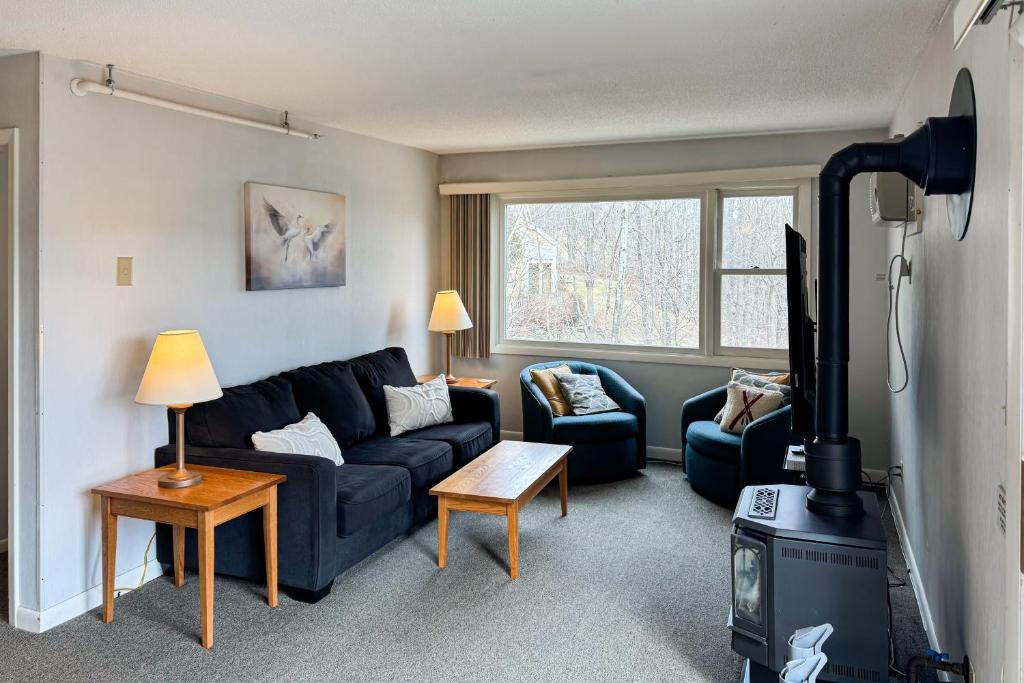 a living room with a couch and a stove at Mountainside Resort F302 in Stowe