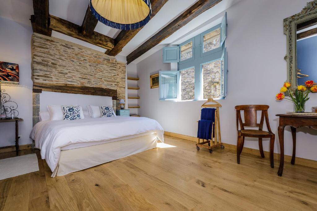 a bedroom with a white bed and a wooden floor at Lou Castel Chambres d'Hôtes in Ségur-le-Château