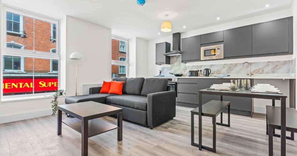 a living room with a couch and a kitchen at 1BR Apartment with Sofa Bed I Prime Town Centre Location I Gold St D-Lux, Modern Amenities, Walk to Train, Bus Stations, Shops & Cafés I Leisure and Business Stays Welcome MULTIPLE UNITS AVAILABLE in Northampton
