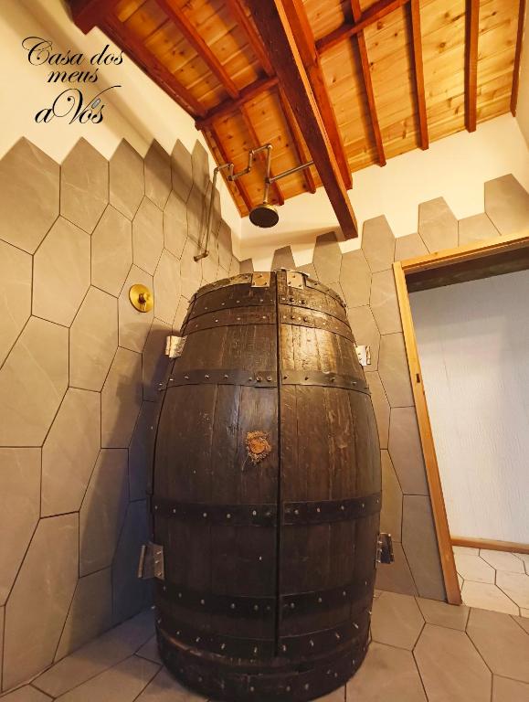 a large wooden barrel in a room with a wall at Casa dos meus avós Mar & Biscoitos in Biscoitos