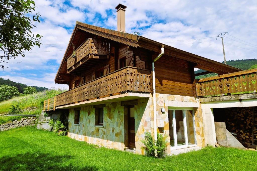 une maison sur une colline herbeuse avec dans l'établissement Chalet de montagne à La Bresse, proche des pistes de ski et des lacs, à La Bresse