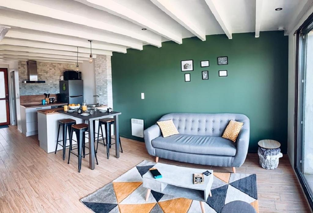 un salon avec un canapé et une cuisine dans l'établissement Charmant appartement T3 avec terrasse en rez de jardin sur le Golf e L'Odet, à Bénodet