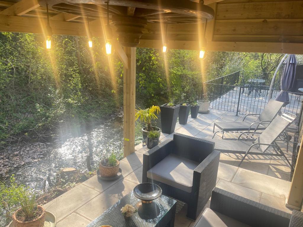 an outdoor patio with chairs and potted plants at Riverside 2 Bedroom Townhouse with Car Charger in Abergavenny