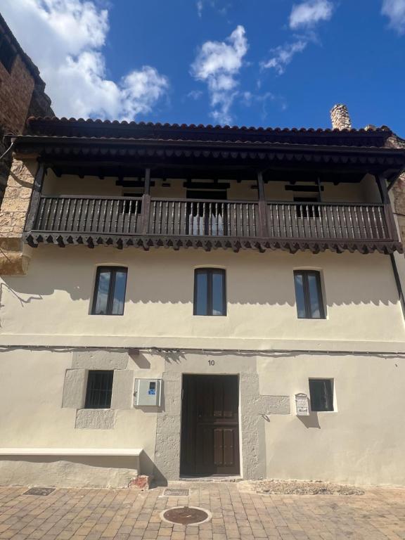 a white building with a balcony on top of it at La Tahona in Orbaneja del Castillo