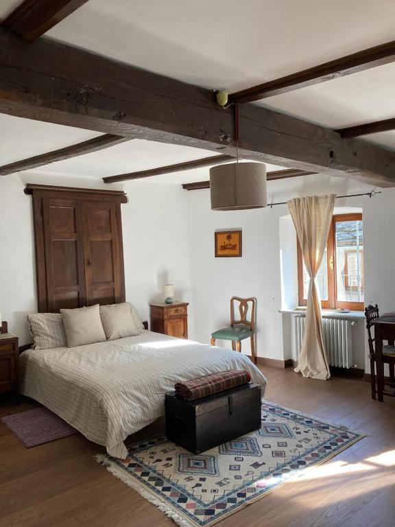 a bedroom with a large bed and a rug at Maison Garavet in Donnaz