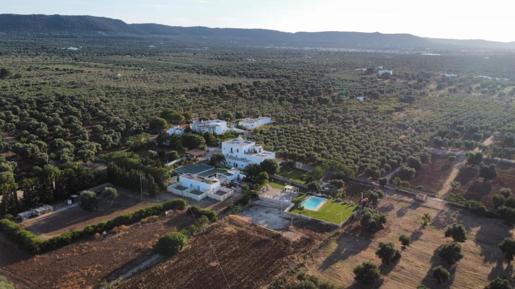 an aerial view of a large white house with trees at Masseria Borgo Santuri in Ostuni