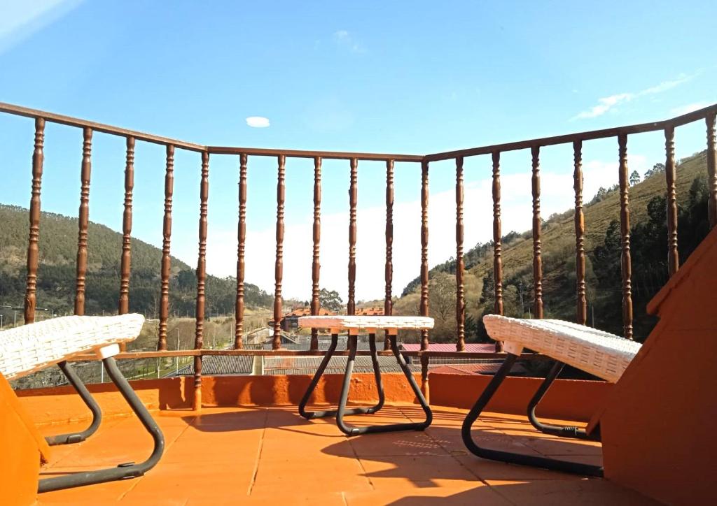 two chairs and a table on a balcony with a view at Atico en Tina Mayor in Unquera
