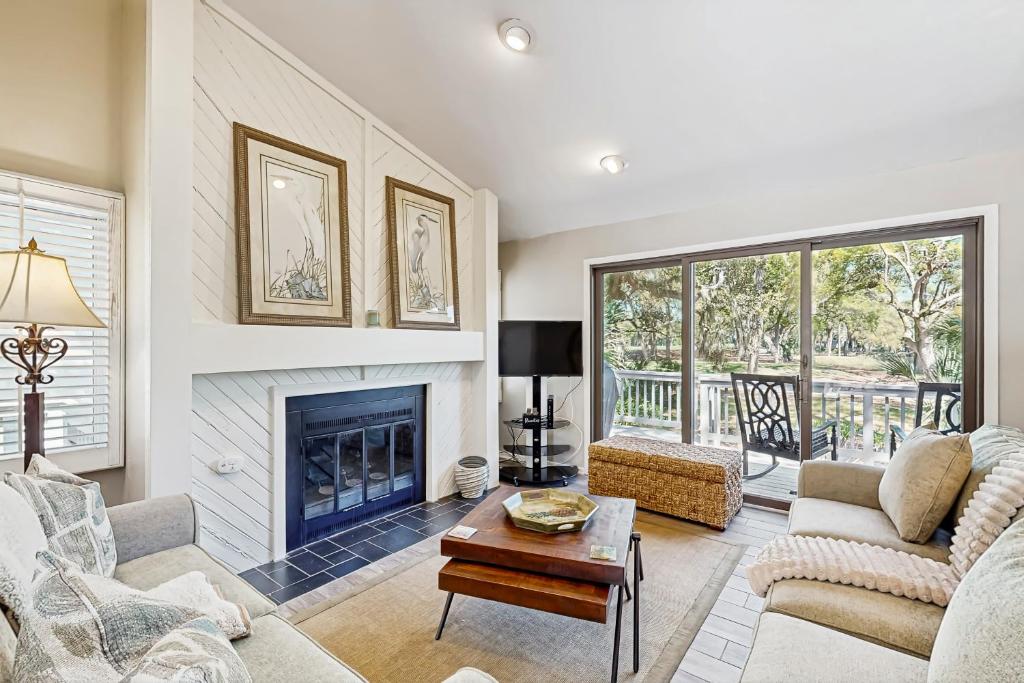 a living room with a fireplace and a table at Surfscoter 94 in Kiawah Island