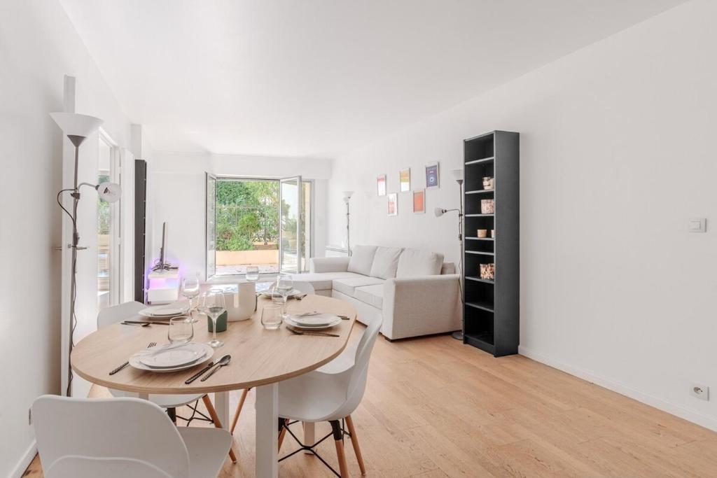 une salle à manger et un salon avec une table et des chaises dans l'établissement Beautiful 4P Apartment with Garden - Paris 16th, à Paris