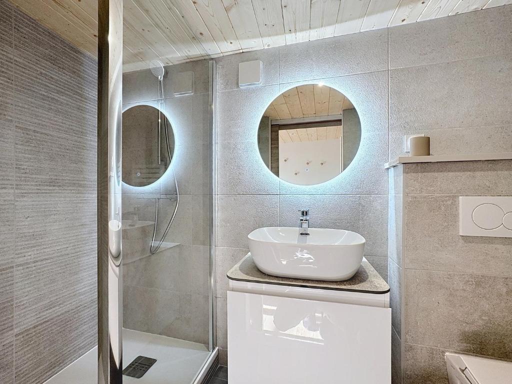 a bathroom with a sink and a shower and a mirror at Fleurie - Anse Centre - Chambre et Salle de bain WC privée - Cuisine partagée in Anse