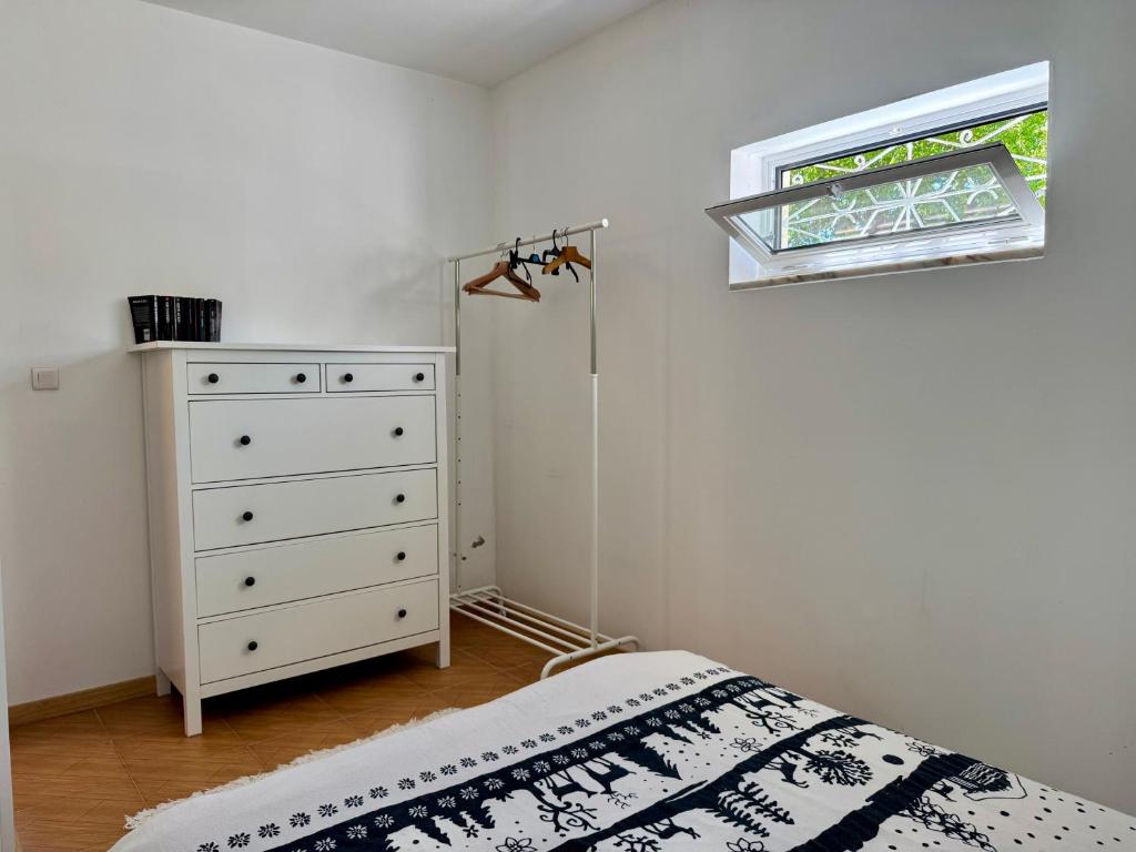 a bedroom with a bed and a dresser and a window at Maison Miranda nord Portugal in Represas