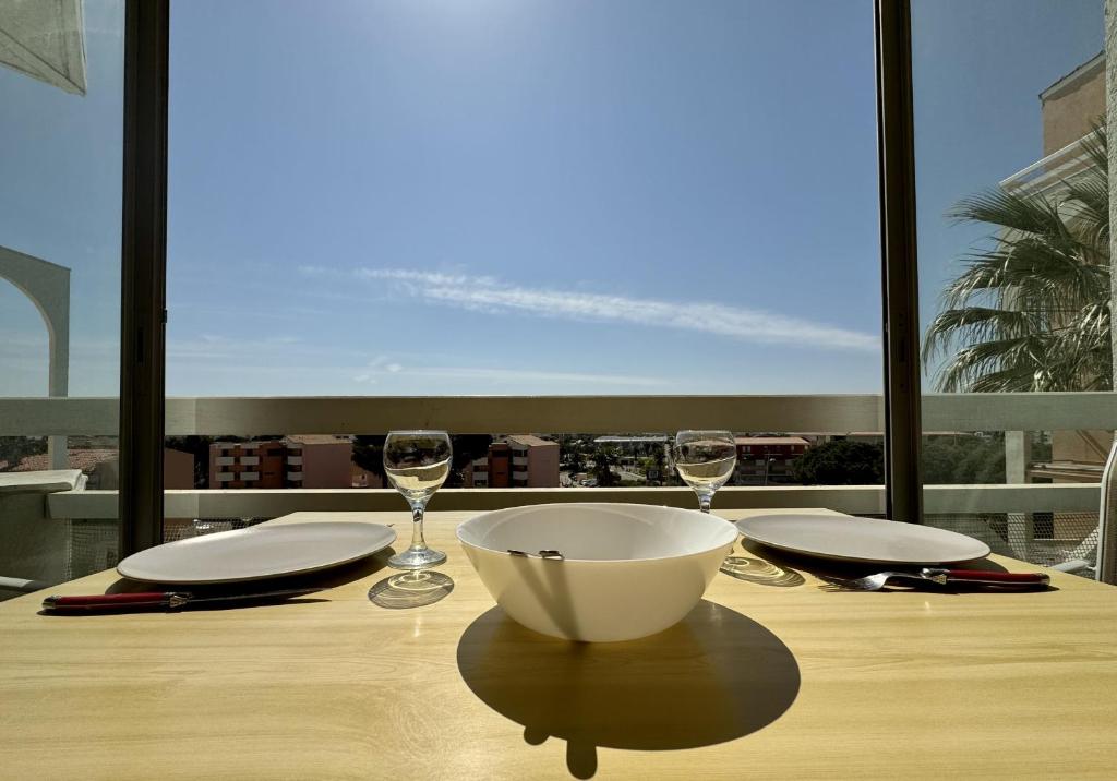 - une table avec un bol et des verres à vin sur le balcon dans l'établissement Sete T2 avec piscine, parking, proche des plages, à Sète