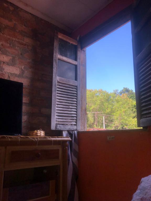 a room with a window and a desk with a view at Rústica Chapas P in Lençóis