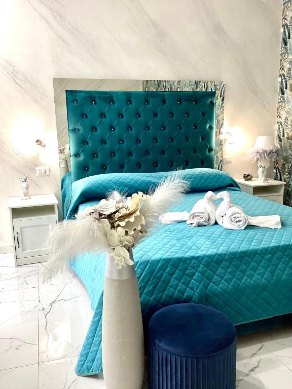a bedroom with a blue bed with a blue headboard at La Vecchia Rosa in Catania