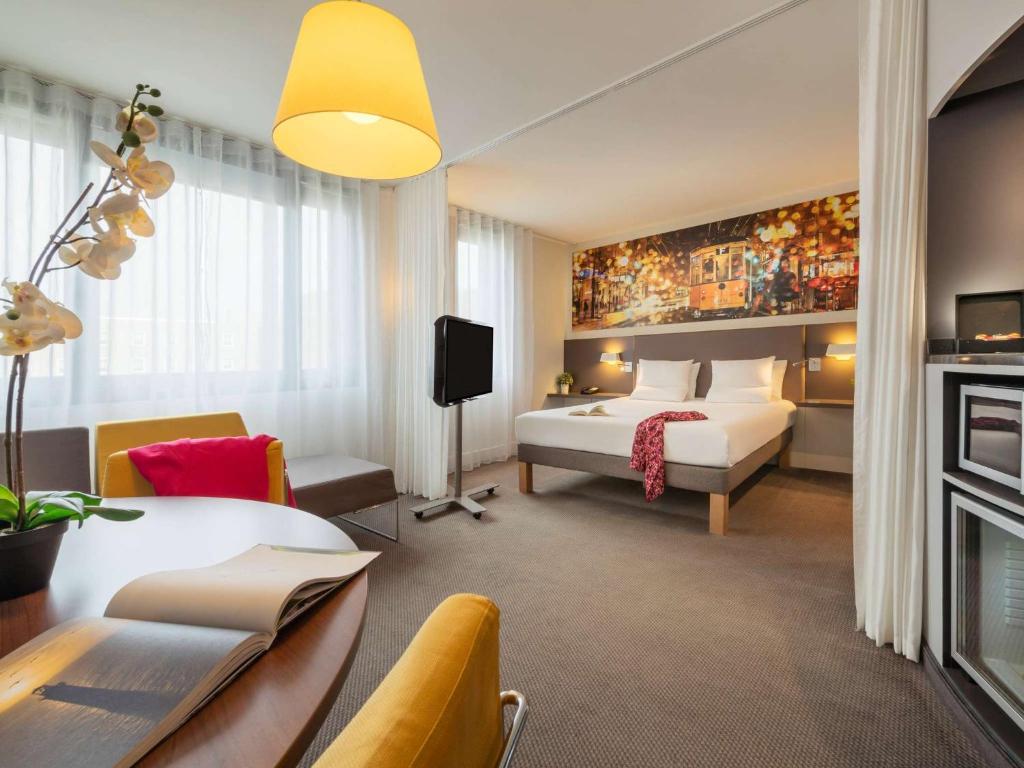 une chambre d'hôtel avec un lit et une télévision dans l'établissement Novotel Suites Paris CDG Airport Villepinte, à Roissy-en-France