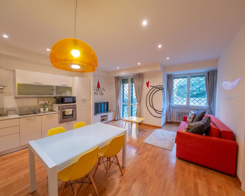 a kitchen and living room with a white table and yellow chairs at San Paolo Apartment in Pisa