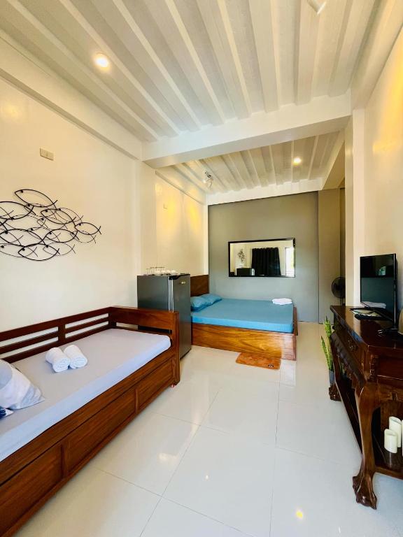 um quarto com duas camas e uma secretária em FN Lodge - town proper em Palompon