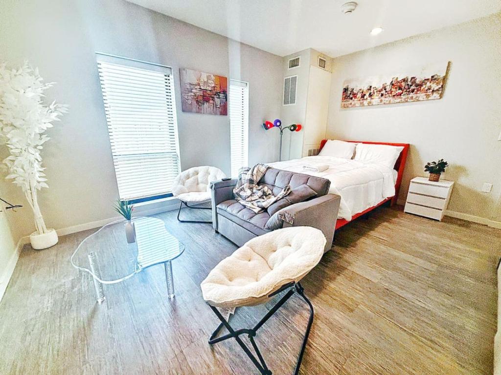 a bedroom with a bed and a couch and a table at Zesty Orange Abode (438) in Des Moines