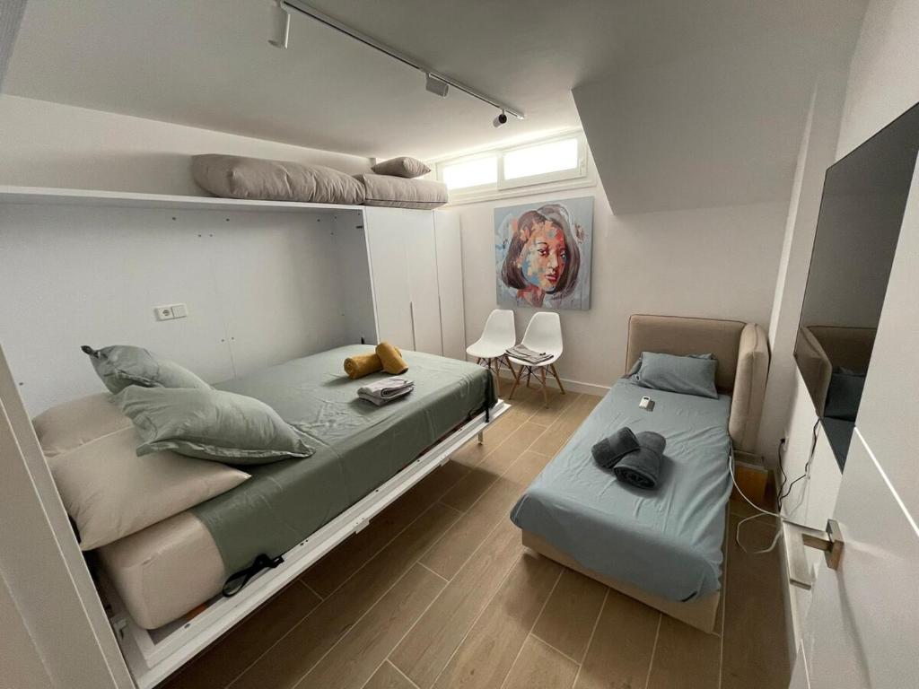 een slaapkamer met twee stapelbedden en een bank bij PALM HOUSE apartment in Tarifa