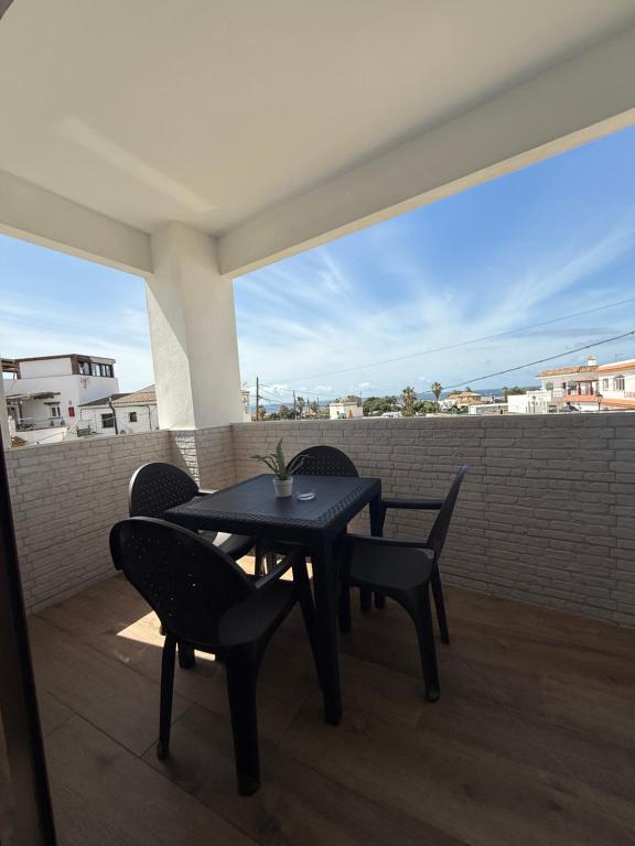 a black table and chairs on a balcony at Apartamentos Bolonia - M a n u e l a in Bolonia
