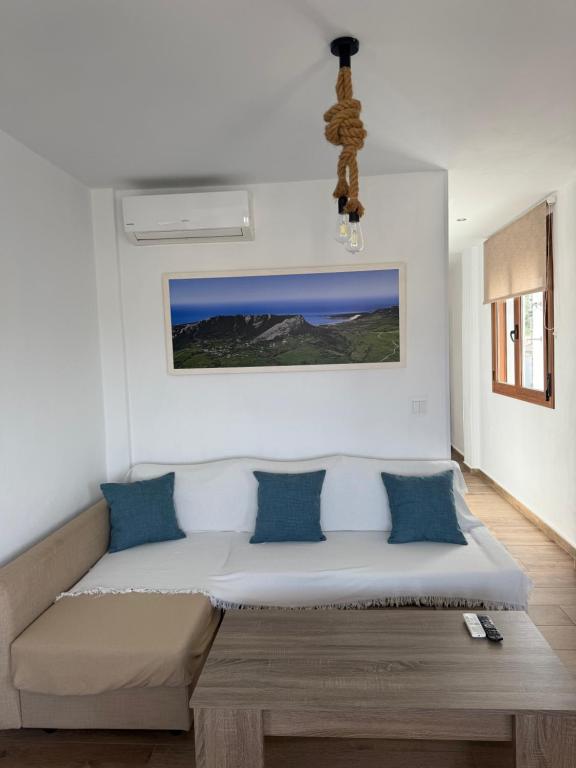 a room with a bed with blue pillows at Apartamentos Bolonia - M a n u e l a in Bolonia