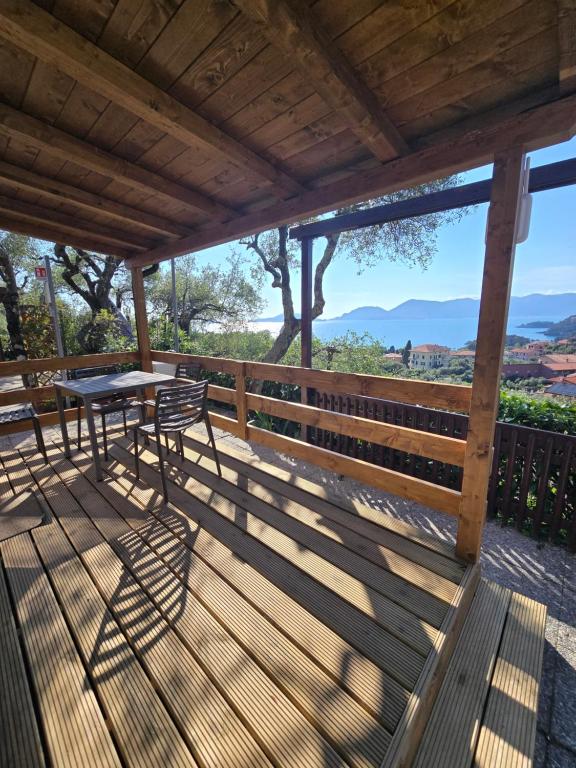 a wooden deck with a table and chairs on it at Campeggio Gianna Golfo dei Poeti in Lerici