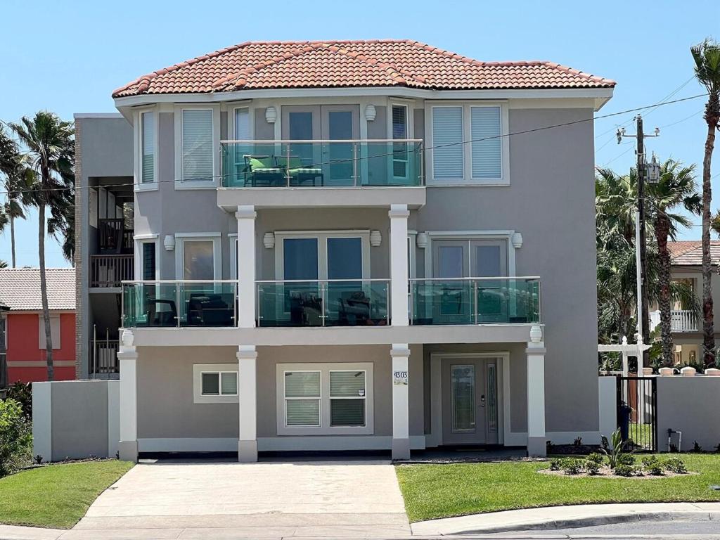 a large white house with a balcony at Fam Reunion, Beachview, EV charger Heated Pool, Jacuzzi, Billiard in South Padre Island