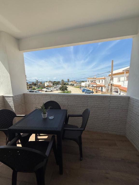 a black table and chairs on a balcony with a view at Apartamentos Bolonia - M a n u e l a in Bolonia