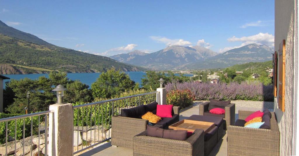 d'un balcon avec deux canapés et une vue sur les montagnes. dans l'établissement 05DAME Dalaromeri, à Savines